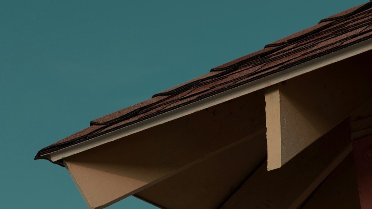 Underside of a roof eave and soffit against a clear blue sky