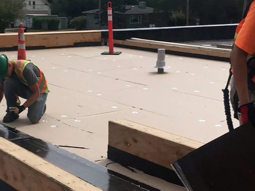 Roofing contractor performing a commercial flat roof repair on an Edmonton property