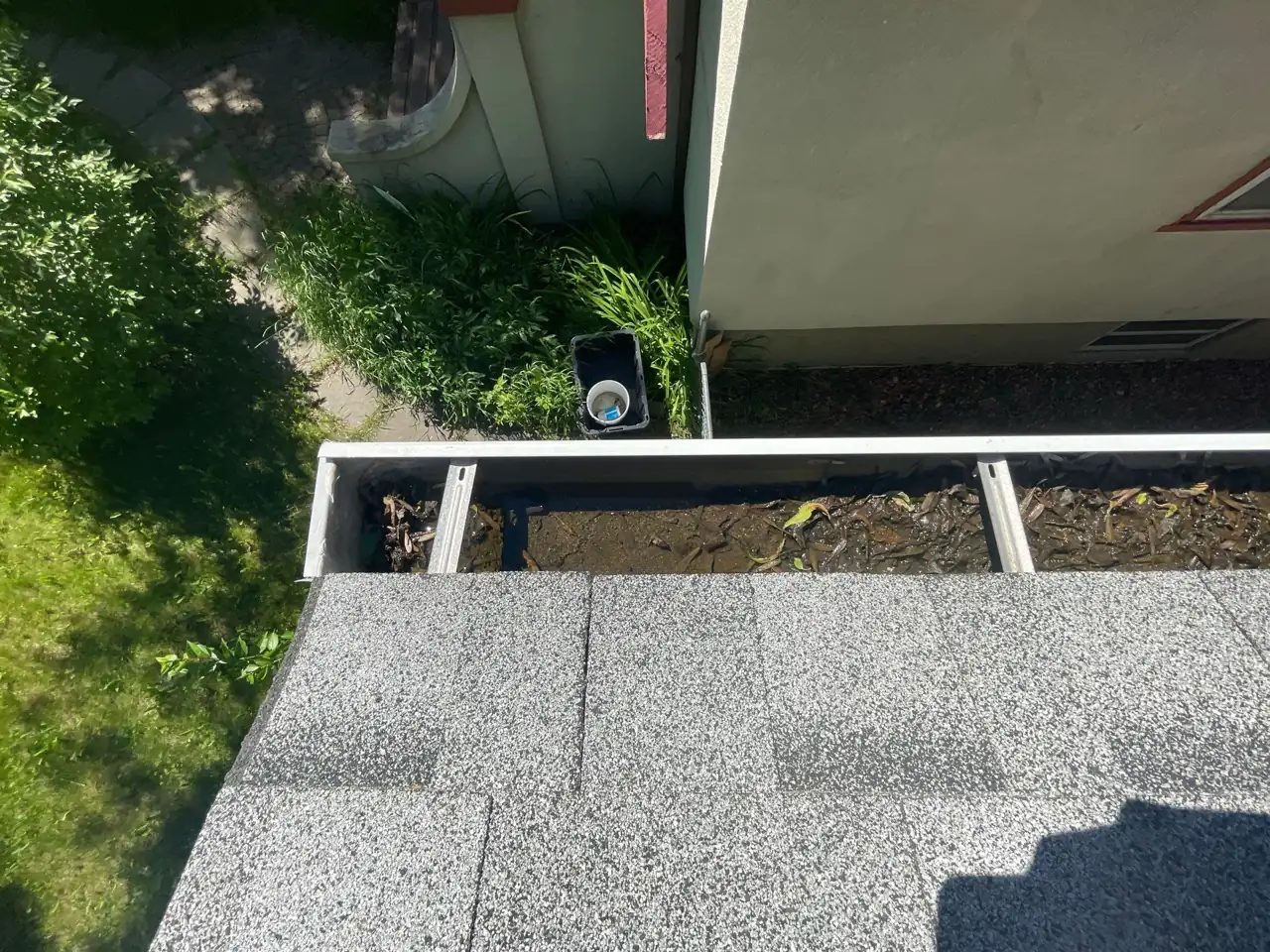 Flushing the gutter run toward the downspout