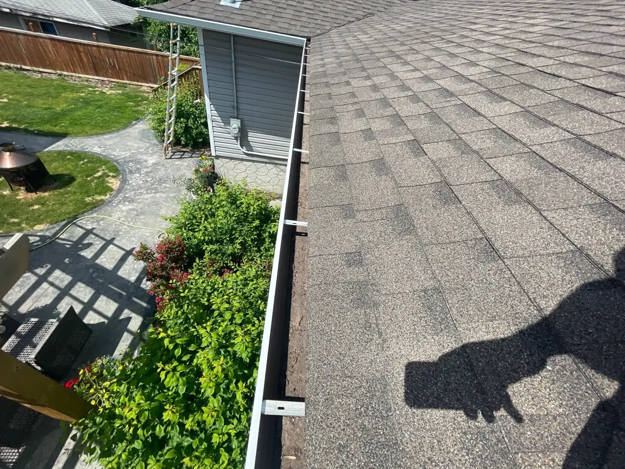 Inspecting the roof while clearing the gutters