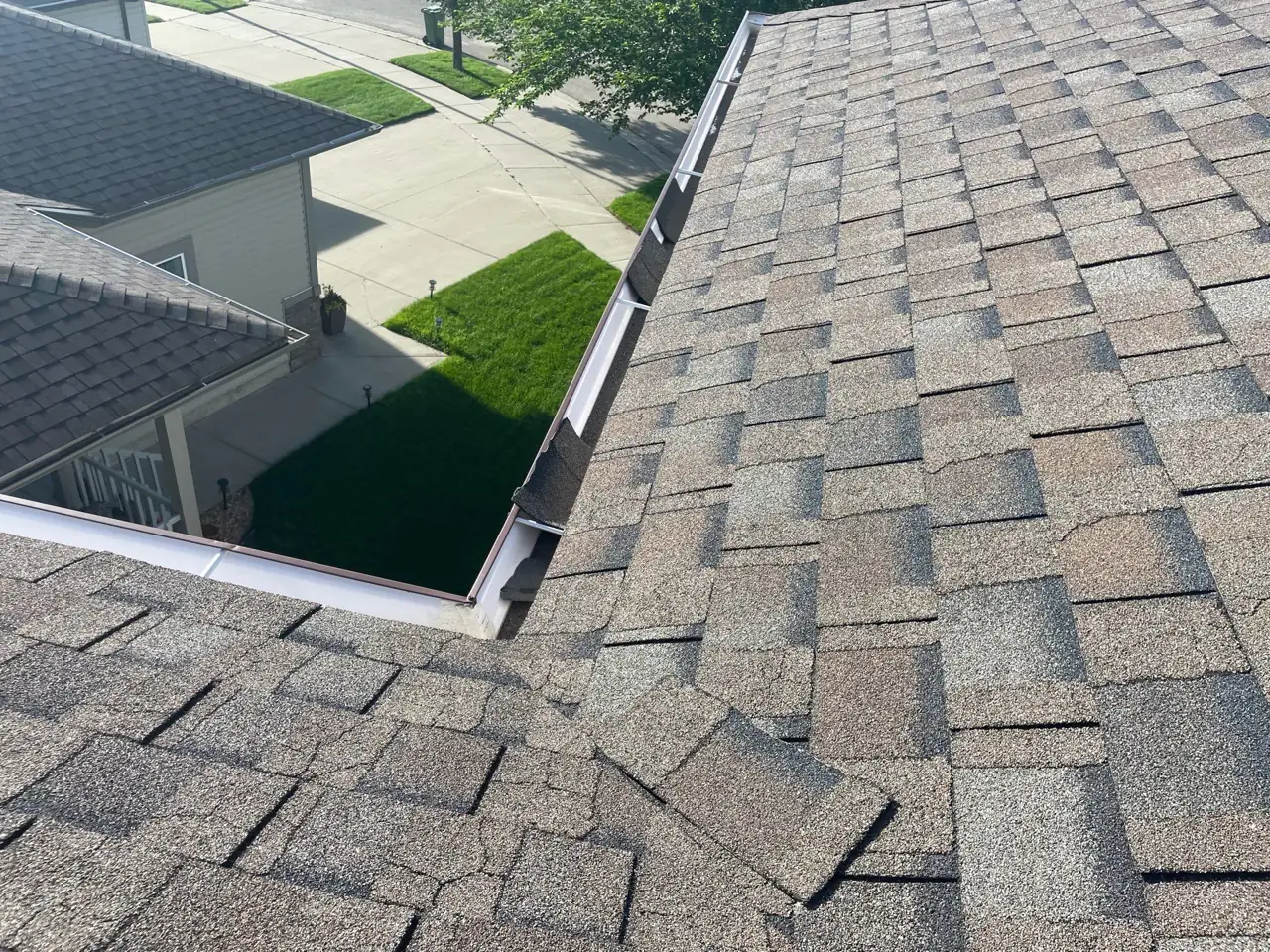 Wind-lifted shingles exposing the roof beneath